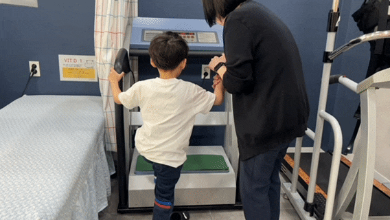 책상 앞에서 긴장한 표정으로 배를 만지는 아이