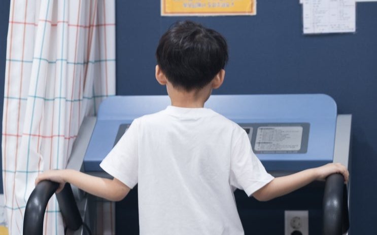 함소아한의원 부산 해운대점에서 체성분과 신장을 재는 장비 위에 선 아이