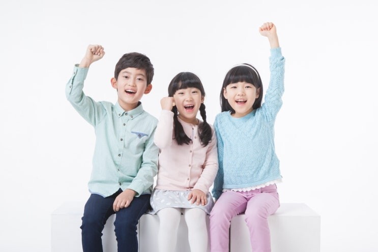 두 팔을 들고 환하게 웃는 세 아이